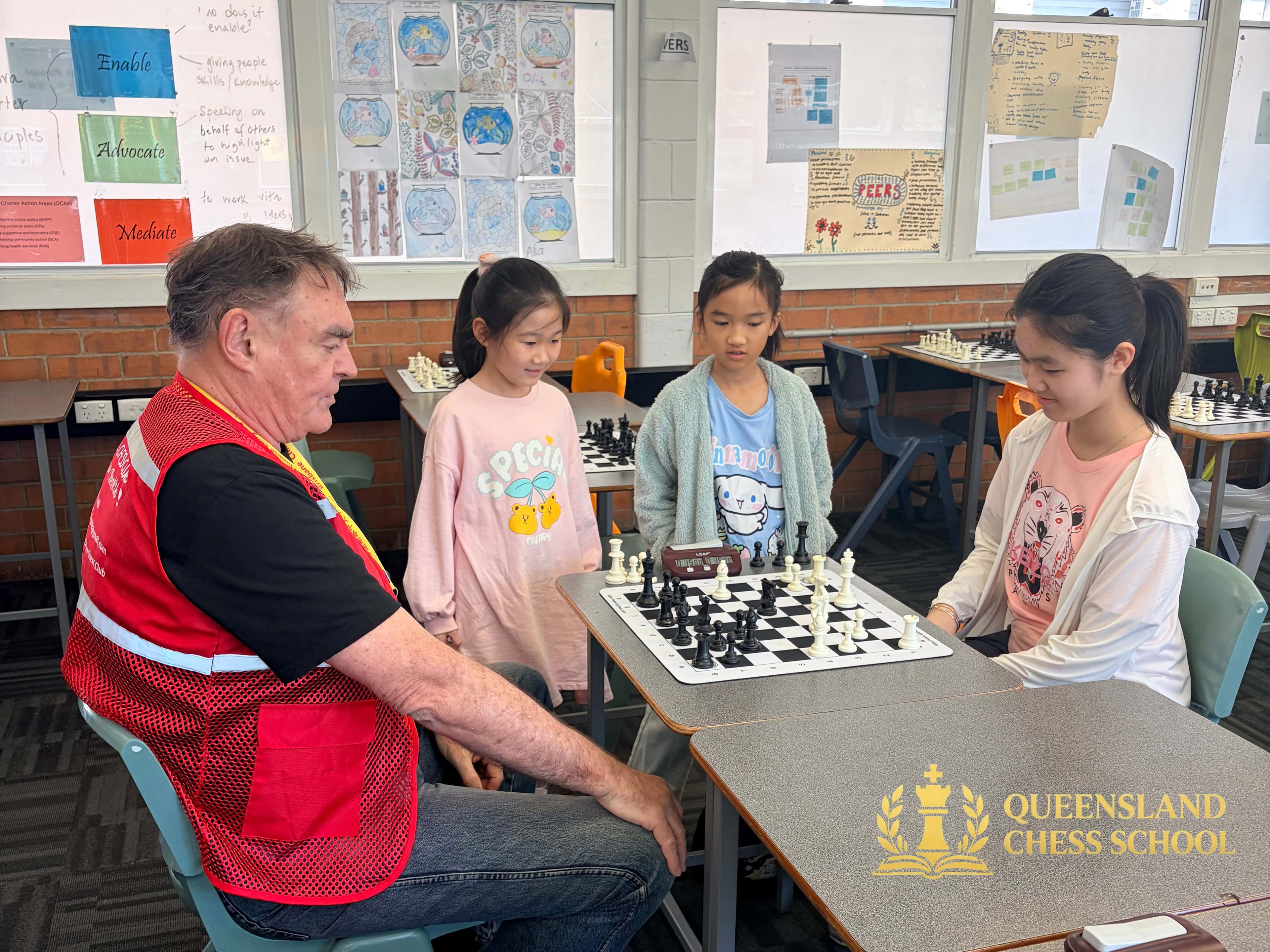 Queens Games 2026, IA David arbiter watching junior girls chess game